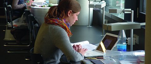 Student sitting in a library (photo: University of Würzburg)
