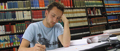 Photo of a student sitting in a library (photo: University of Würzburg)
