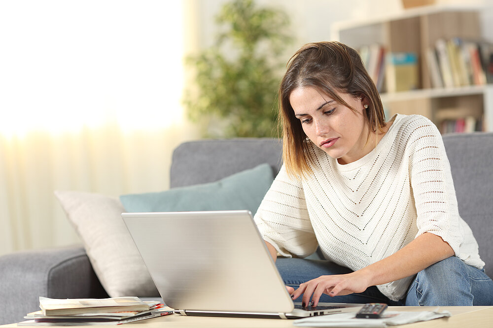 Serious woman checking laptop online content at home