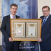 Dokument von Weltrang: Universitätspräsident Alfred Forchel überreicht Oberbürgermeister Christian Schuchardt ein Faksimile der weltweit ersten Nobelpreis-Urkunde. Sie ging an den Physiker Wilhelm C. Röntgen.