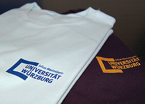 Zwei T-Shirts aus dem Uni-Shop. Es gibt dort auch noch andere Designs. Foto: Robert Emmerich