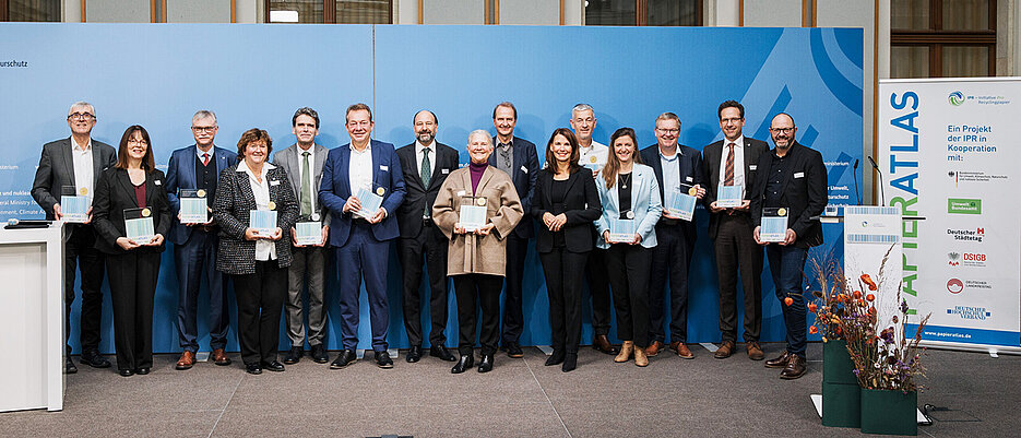 Unikanzler Uwe Klug (Dritter von links) nahm die Auszeichnung in Berlin entgegen. Auch dabei waren Vertreterinnen und Vertreter von Städten, Landkreisen und anderen Hochschulen.